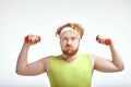 Red haired, bearded, plump man is holding the dumbbells Royalty Free Stock Photo