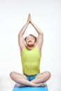 Red haired, bearded, plump man is sitting on the mat, he is meditating