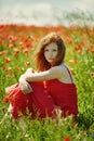 Red haired beautiful girl in poppy field Royalty Free Stock Photo