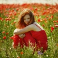 Red haired beautiful girl in poppy field Royalty Free Stock Photo