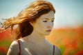 Red haired beautiful girl in poppy field Royalty Free Stock Photo