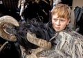 A red-haired boy with a freckle in a Krampus costume stands in anticipation of the procession, Austria, Salzburg