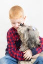 a red-haired boy hugs his beloved dog and smiles at her. The pet licks the boy's face with its tongue Royalty Free Stock Photo