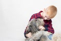 a red-haired boy hugs his beloved dog and smiles at her. The pet licks the boy& x27;s face with its tongue Royalty Free Stock Photo