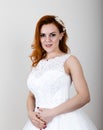 Red-haired bride in a wedding dress holding wedding bouquet, bright unusual appearance. Beautiful wedding hairstyle and