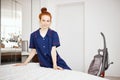 A female chambermaid making bed in hotel room Royalty Free Stock Photo