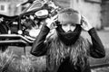 Red-haired curly woman in a helmet near a motorcycle. Monochrome. Royalty Free Stock Photo