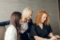 Red haired female corporate mentor helps employees with computer work in office