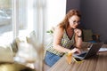 Red-haired freelance writer sitting in cafe while working hard Royalty Free Stock Photo