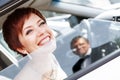 Red-haired funny bride in the car smiling groom. Woman 35 years. Wedding