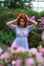 Red-haired girl in arranger where azalea blooms in a colorful flying dress Royalty Free Stock Photo