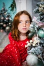Red-haired girl dreams of near the Christmas tree. garland, lights, festive, new year Royalty Free Stock Photo
