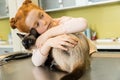Red haired girl embrace her cat at veterinary clinic Royalty Free Stock Photo