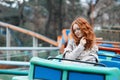 Red-haired girl with freckles at an amusement park