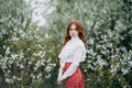 Red-haired girl with freckles in cherry blossom Royalty Free Stock Photo