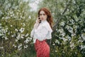 Red-haired girl with freckles in cherry blossom Royalty Free Stock Photo