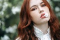 Red-haired girl with freckles in cherry blossom Royalty Free Stock Photo