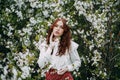 Red-haired girl with freckles in cherry blossom Royalty Free Stock Photo