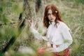 Red-haired girl with freckles in cherry blossom Royalty Free Stock Photo