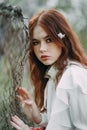 Red-haired girl with freckles in cherry blossom Royalty Free Stock Photo