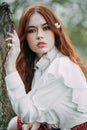 Red-haired girl with freckles in cherry blossom Royalty Free Stock Photo