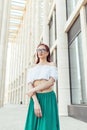 Red-haired girl in glasses stands against the background of a beautiful modern building Royalty Free Stock Photo