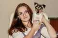 Red-haired girl holding a puppy Jack Russell. Royalty Free Stock Photo