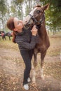 Red-haired girl kisses her favorite horse