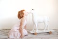 Red-haired girl kisses toy horse Royalty Free Stock Photo