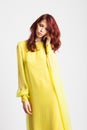 Red-haired girl in long elegant yellow dress
