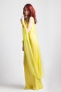 Red-haired girl in long elegant yellow dress