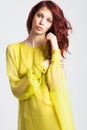 Red-haired girl in long elegant yellow dress