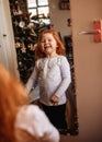 Red-haired girl looking in the mirror and laughing Royalty Free Stock Photo