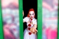 Red haired girl with makeup on her face in style of scary clown.