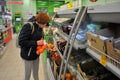 Red-haired girl in a medical mask chooses fruits at the grocery store.