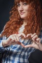 Red-haired girl shows heart