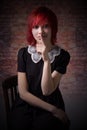 Red-haired girl sitting on chair calls for silence