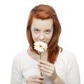 Red haired girl smelling on a flower