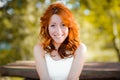 The red-haired girl smiles sweetly, laughs back. real emotions. A pretty woman with naturally curly red hair and a happy, vibrant Royalty Free Stock Photo
