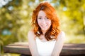 The red-haired girl smiles sweetly, laughs back. real emotions. A pretty woman with naturally curly red hair and a happy, vibrant Royalty Free Stock Photo