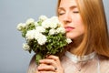 Red-haired girl in the studio with a white bouquet of flowers Royalty Free Stock Photo