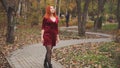 Red-haired girl walking on the sidewalk in the park