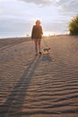 Red-haired girl walks on the beach, sand with a small dog-a Yorkshire Terrier Royalty Free Stock Photo