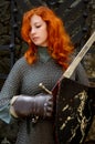 Red-haired girl-warrior in iron chain mail with a sword