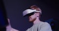 A red-haired guy in virtual reality glasses controls the simulator in 5D