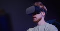 A red-haired guy in virtual reality glasses controls the simulator in 5D
