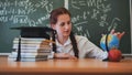 A red-haired high school senior poses against a backdrop of books, a globe and a graduation cap. Royalty Free Stock Photo