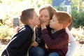 Sons kissing happy mother