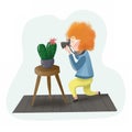 Red-haired photographer photographer photographs cactus.