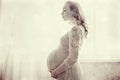 Red-haired pregnant woman in a delicate pink lace dress Royalty Free Stock Photo